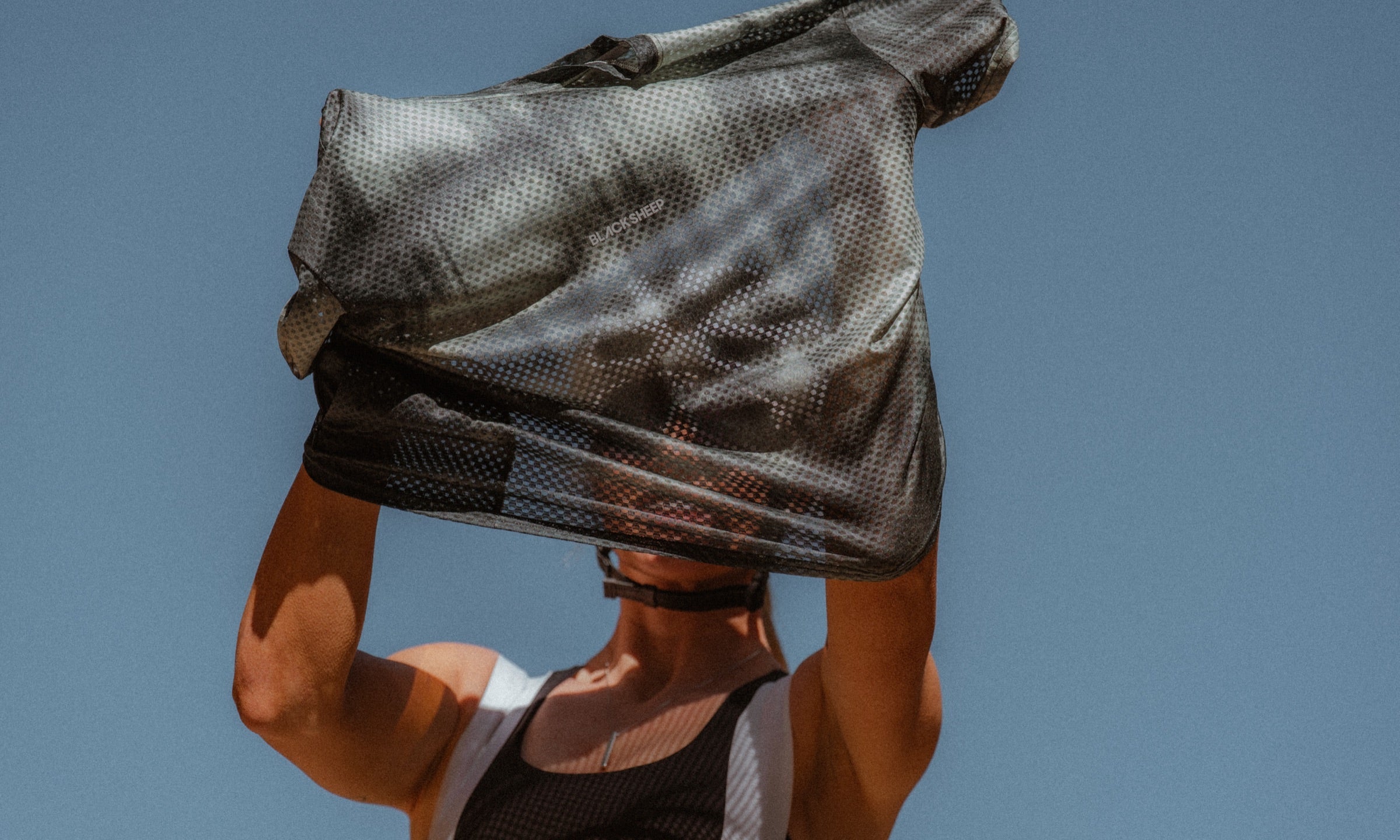 The Enduro Mesh Tee held up against the sky